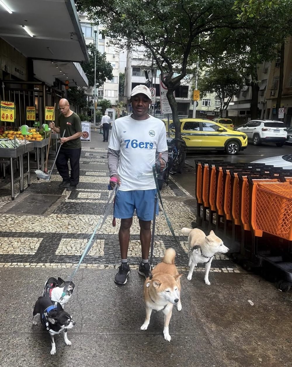 Breno passeando com uma turma de quatro cães pela calçada